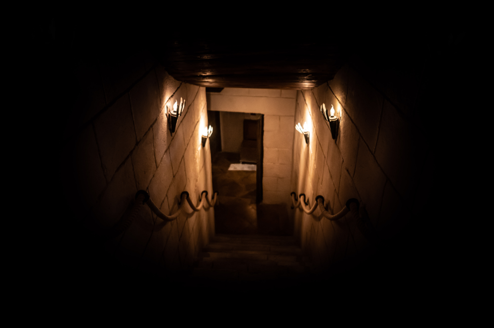 Escalier éclairé menant dans les souterrains du Donjon